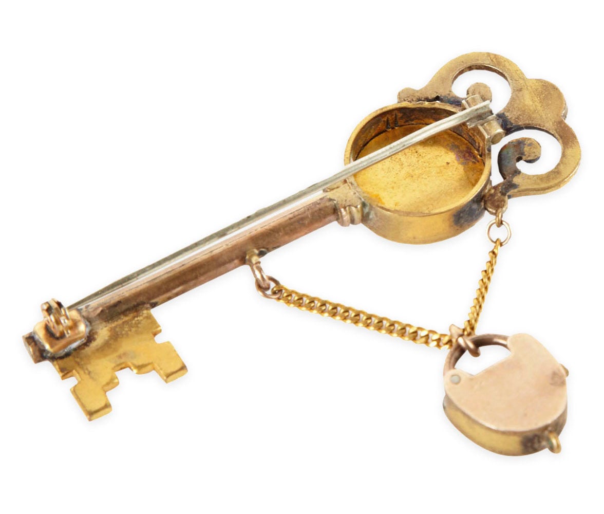 Broche Victorienne Lock and Key Brooch de la fin du 19ème siècle. Le profil d'un gladiateur est incrusté dans la clé dans des métaux de différentes couleurs, avec un cadenas suspendu en dessous. Métal rempli d'or. états-Unis des années