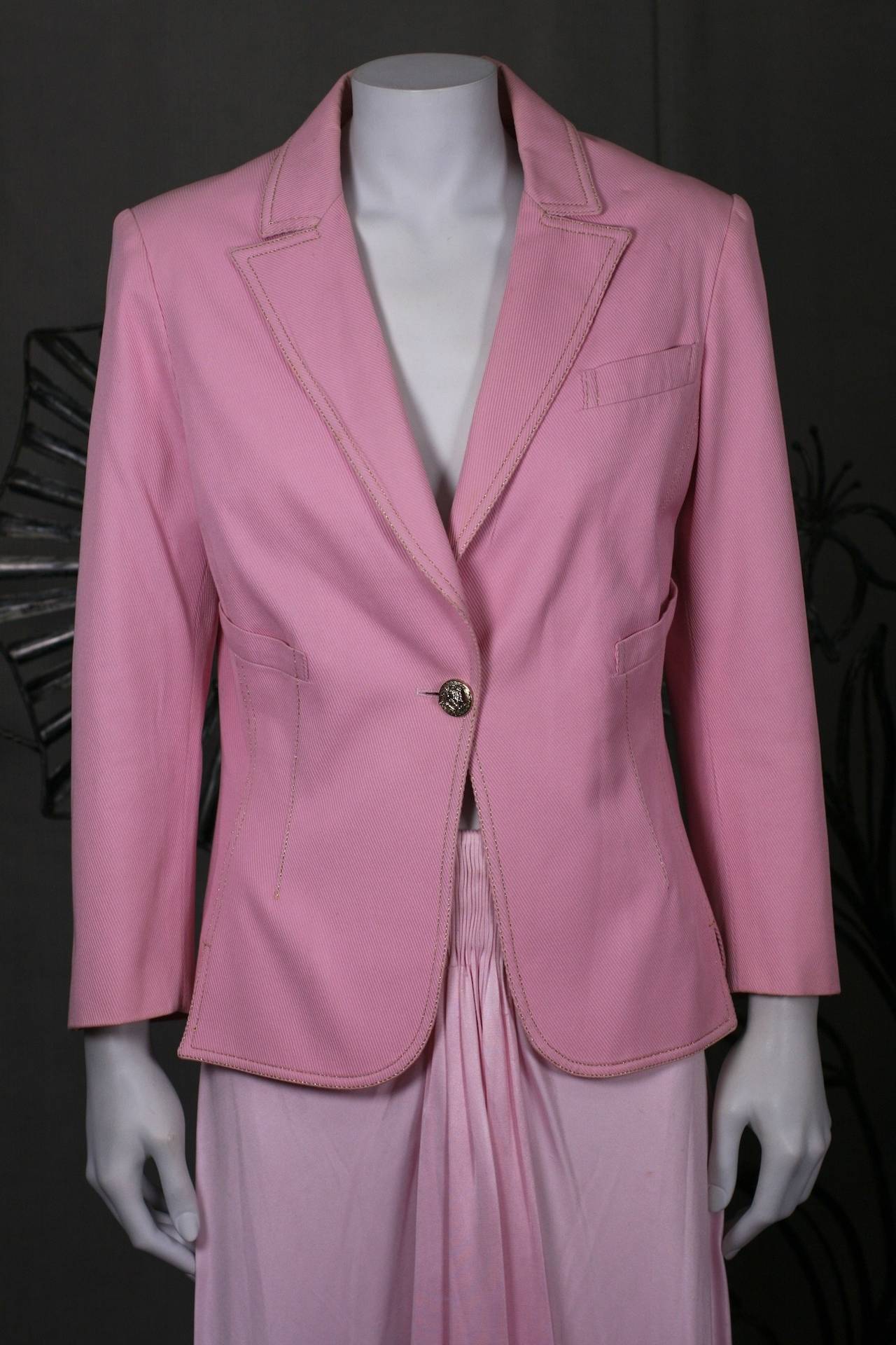 Gianni Versace Pink Denim Suit Jacket with draped jersey skirt. Fit and flare jacket has one logo button closure and is top stitched in gold lurex thread. Pink jersey skirt is gathered at front and back and falls into full drape, side zip entry.