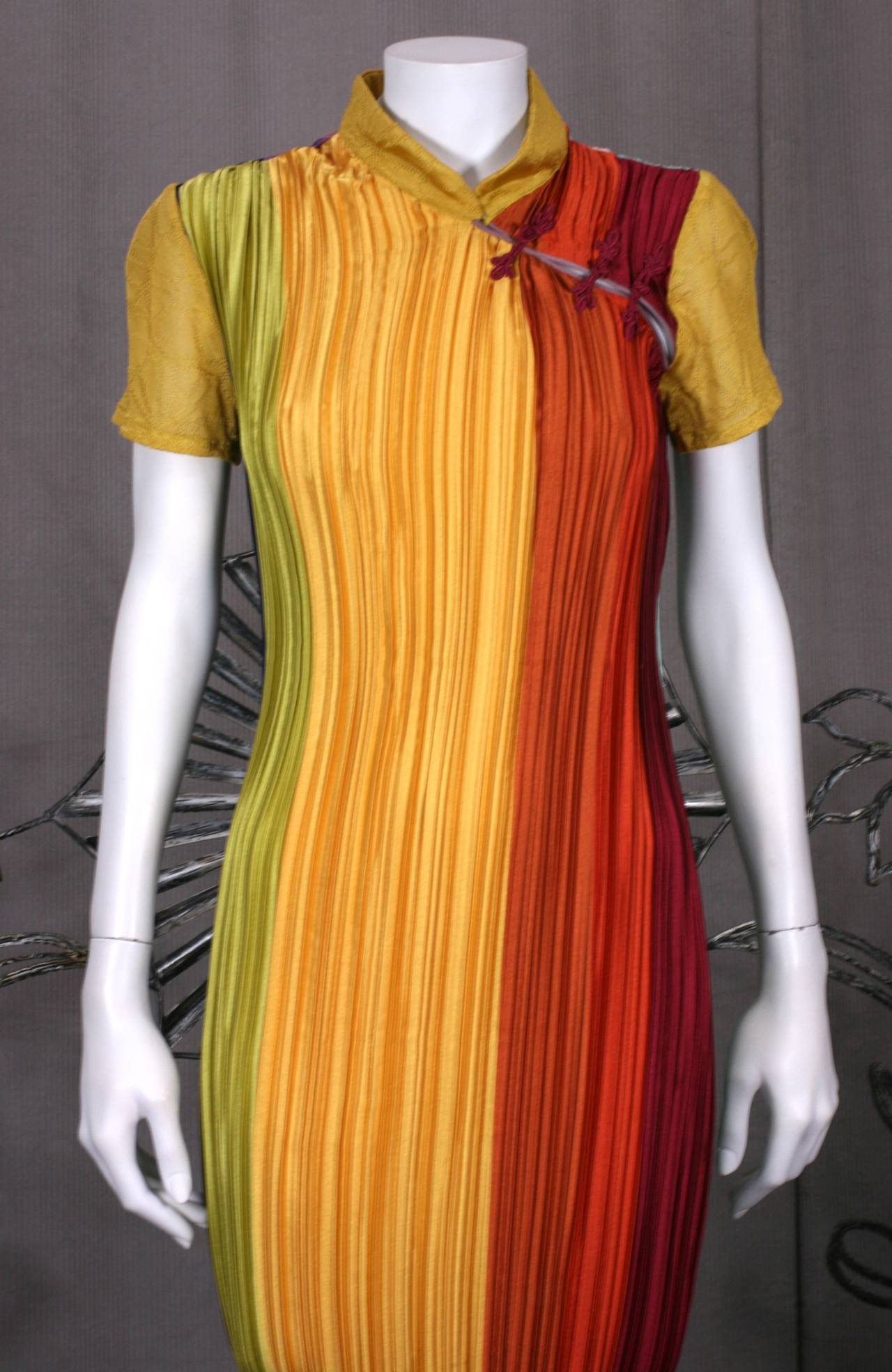 John Galliano Cheongsam evening dress early 2000s. An example of Galliano's morphing of eras and styles, the classic chinese cheongsam is recreated with lengths of Mariano Fortuny style pleating in jewel toned ombre colorings with traditional frog