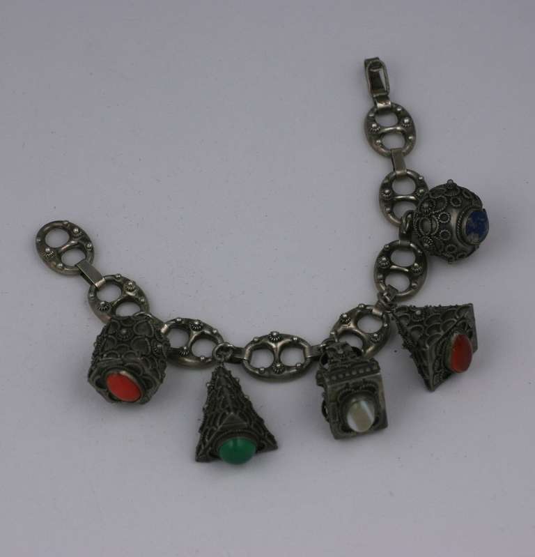Chunky Italian Fob Bracelet in sterling silver set with semi precious stones (coral, agate, green onyx, carnelian, lapis) on their bases. Elaborate Etruscan work detailing on each fob and links. 1950's Italy.
Bracelet 8