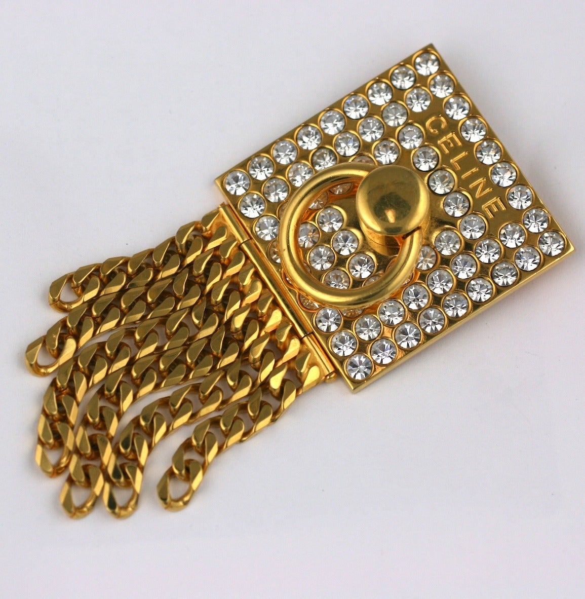 Celine pave door knocker logo brooch of 18 kt gilded metal, crystal pave and curb chain fringe. Signed, 