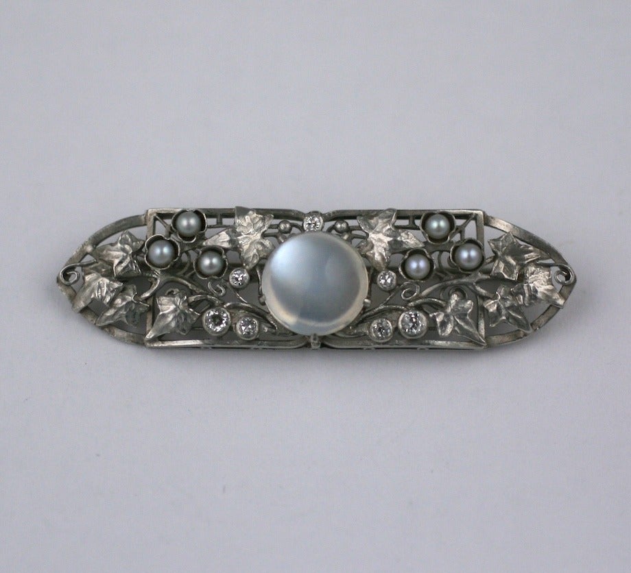 Lovely Arts and Crafts Platinum, Moonstone and Diamond Brooch from the turn of the 20th Century attributed to Frank Gardner Hale. Beautifully hand crafted with ivy leaf and vine motifs, interdispersed with bezel set diamonds, pearls and a large