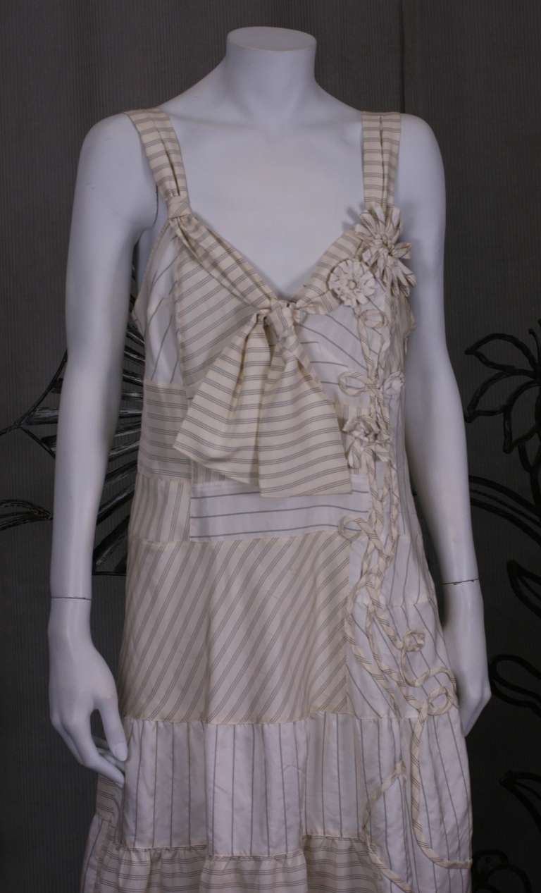 Clever Moschino dress made from left over lining stripes. The various patterns are gathered, ruffled and appliqued to form a charming summer dress with floral detailing. Side zip entry. 2000's Italy. Excellent condition. 
Length 41