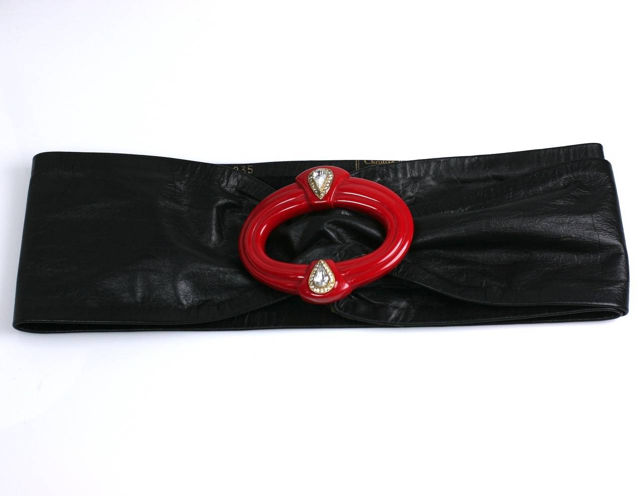 Christian Dior Art Deco Revival Gürtel aus breitem, weichem schwarzen Leder mit strassbesetzter, geschnitzter roter Bakelitschnalle. Vollständig einstellbar, keine Größe. 1980er Jahre Frankreich.
Ausgezeichneter Zustand. Lederteil 36