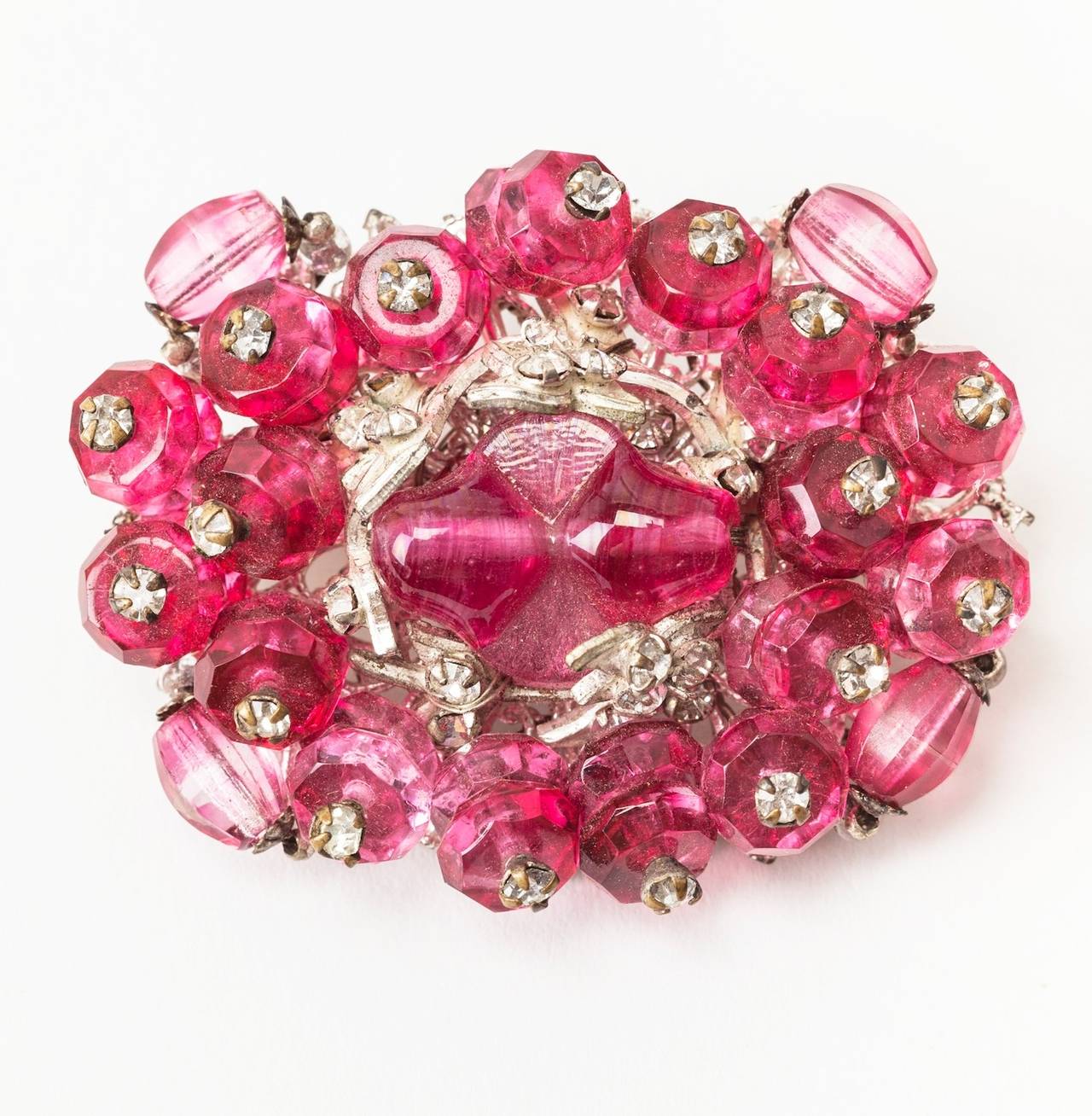 Miriam Haskell ruby faceted crystal and pate de verre brooch set on silver gilt with pegged rhinestones and signature rose montees stones. 
Excellent condition. 1950's USA.