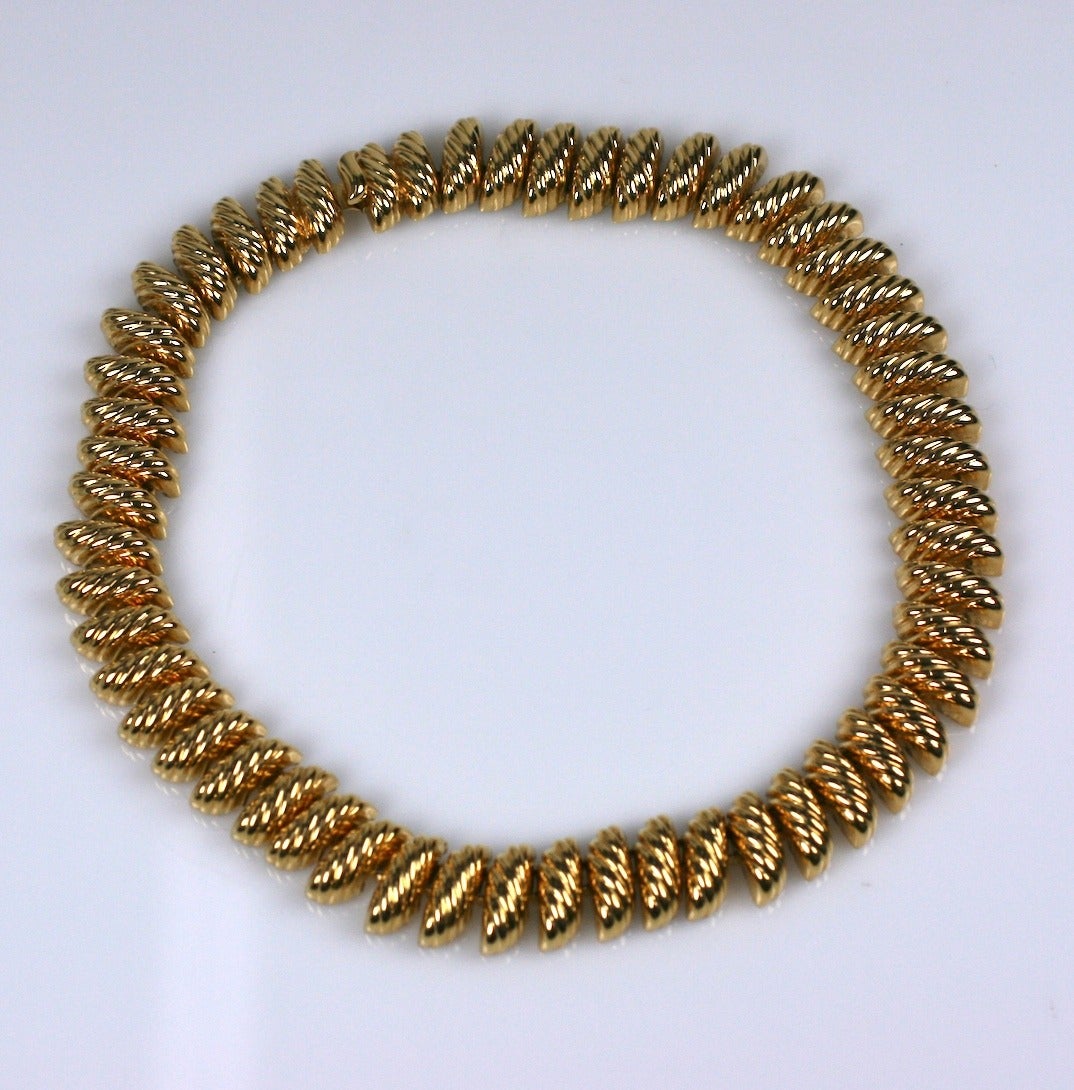 Collier métallique à maillons dorés côtelés des années 1980, de haute qualité, lourd et attrayant.
Des maillons en forme de marquise, côtelés et en forme de dôme sont répétés sur tout le collier. Look très 