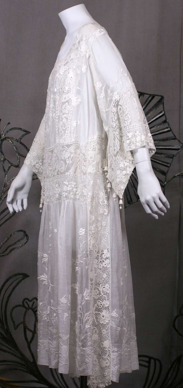 Afternoon dress from the 1920's with elaborate floral embroidery and inserts of Irish crochet work and Filet. Incredible handwork and craftsmanship with handmade bell ornaments hanging from sleeve edge. France 1920's , Very Good Condition. Small