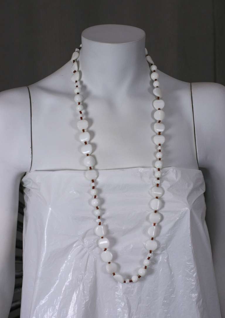 Miriam Haskell long necklace of petal shape milk glass beads and small dark 
topaz spacers,adjustible signature hook closure.

Length 31.75