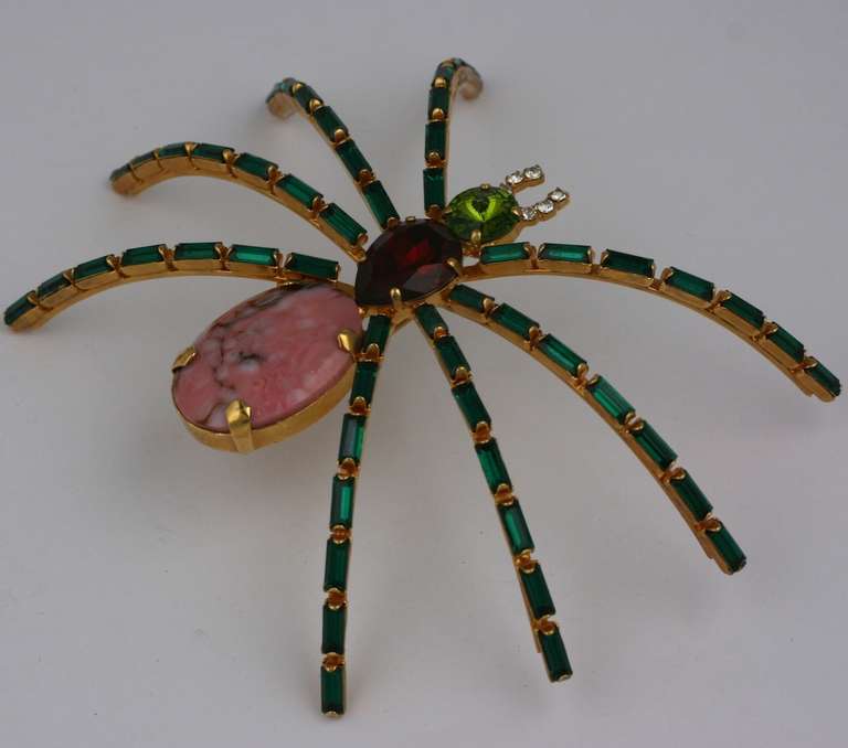 Large and imposing spider brooch of colored pastes with a rhodochrosite body. Emerald baguettes form the curved legs with a peridot paste head and faux ruby pear shaped body. Excellent quality made in Germany 1980's.  4