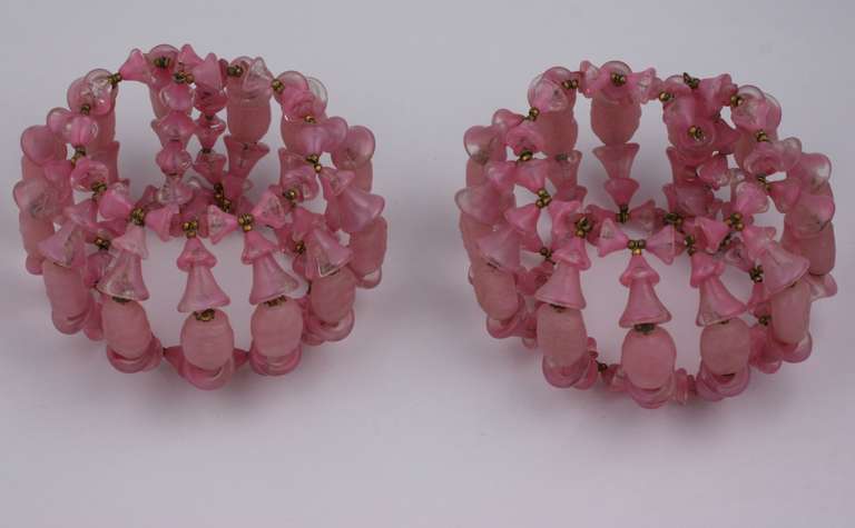 Miriam Haskell Manchettes composées de fleurs de clochettes en pate de verre rose et de perles ovales en quartz rose imitation enfilées sur des fils à ressort.
H 2.50