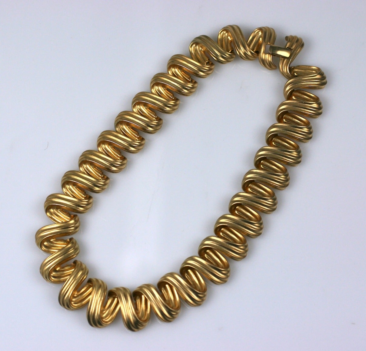Attractive gilt necklace with links resembling looped articulated ribbons. 
15