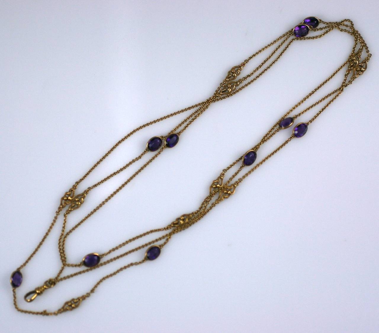 Art Nouveau Amethyst Long Chain in 18K gold with original bloom. Bezel set deep amethysts of approximately 1.5 carats each are interdispersed with Art Nouveau whiplash stations alternating throughout the chain. 

60