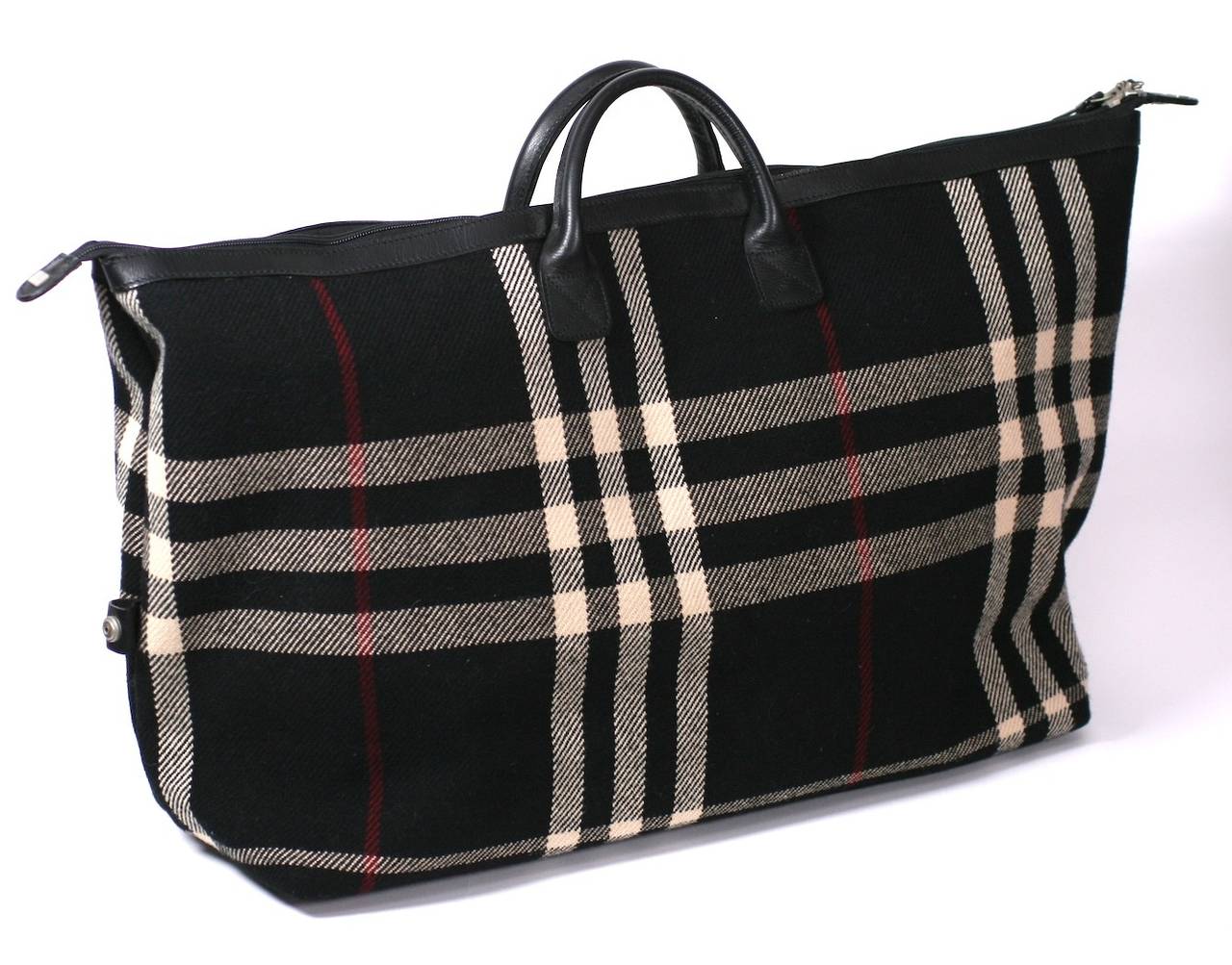 Burberry Plaid Weekender in signature wool plaid with leather trim and  burgundy logo liner. One zipper pocket inside as well as one snap pocket. The bag functions perfectly ,however, the snaps at the ends of the zipper do not function. They are