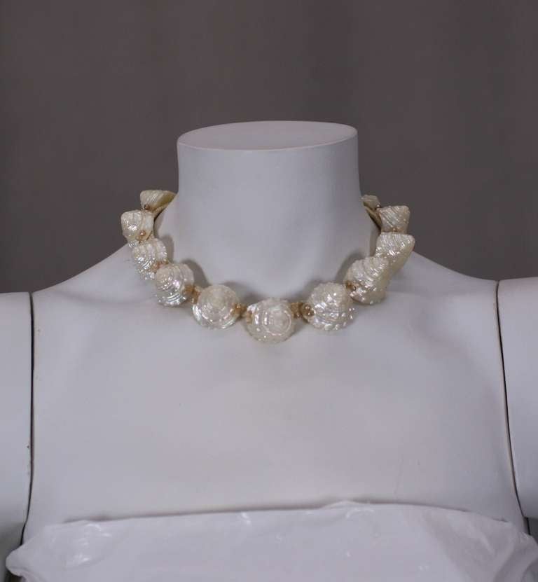 1930's Resort jewelry in the form of genuine shells sewn on a ribbon base. Faux pearls are added for detail. The clip earrings are have mother of pearl discs sewn into the base of the shell. 14.5