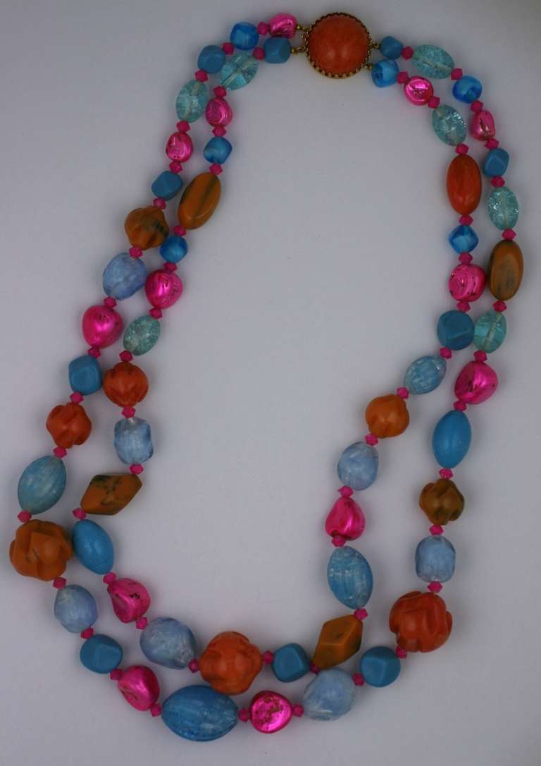 Hattie Carnegie double strand beads of shocking pink iridiscent pearl, amber and pearlized pale blue bakelite. Excellent condition. 1950's USA. 
L 25