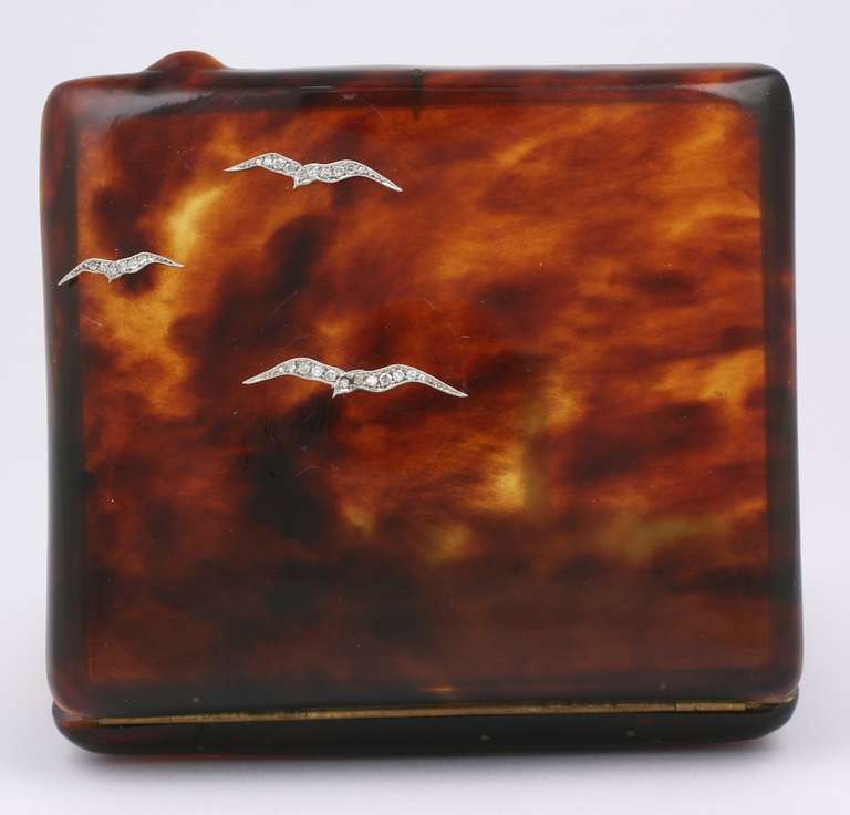 Elegant Art Deco tortoiseshell cigarette case with applied diamond and platinum seagulls. The mottling in the natural tortoiseshell creates the feeling of birds flying through the clouds. Good condition. USA 1930's. 3.25