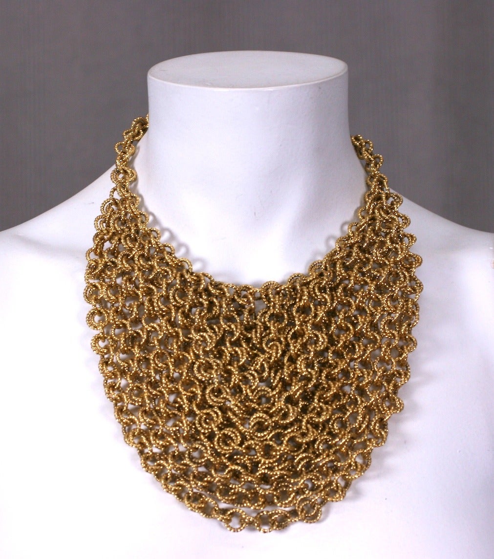 Gilt chain bib made of multiple lengths of graduated chain which swag and form a bib formation. Striking textured double link gilt chain. Length 15.5
