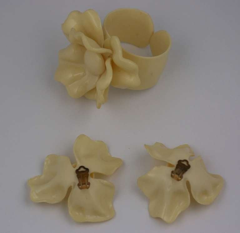 Oversized celluloid pansy suite from the 1950's USA. Open back cuff with large 3 dimensional flower and matching clip on earrings. Cuff: Small size. Earrings 2.5