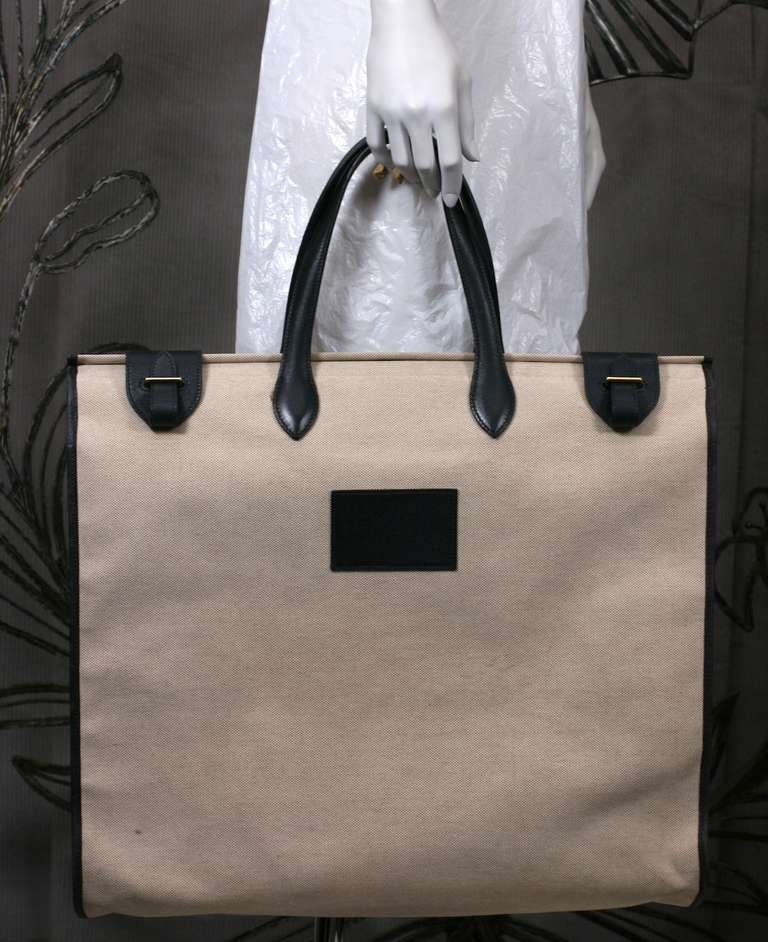 Elegant unisex tall tote of oatmeal toile with navy calf leather fittings by Hermes, Paris. Beautiful quality with restrained buckle designs at top edge. Timeless and exceptional. Very Good condition. 
18