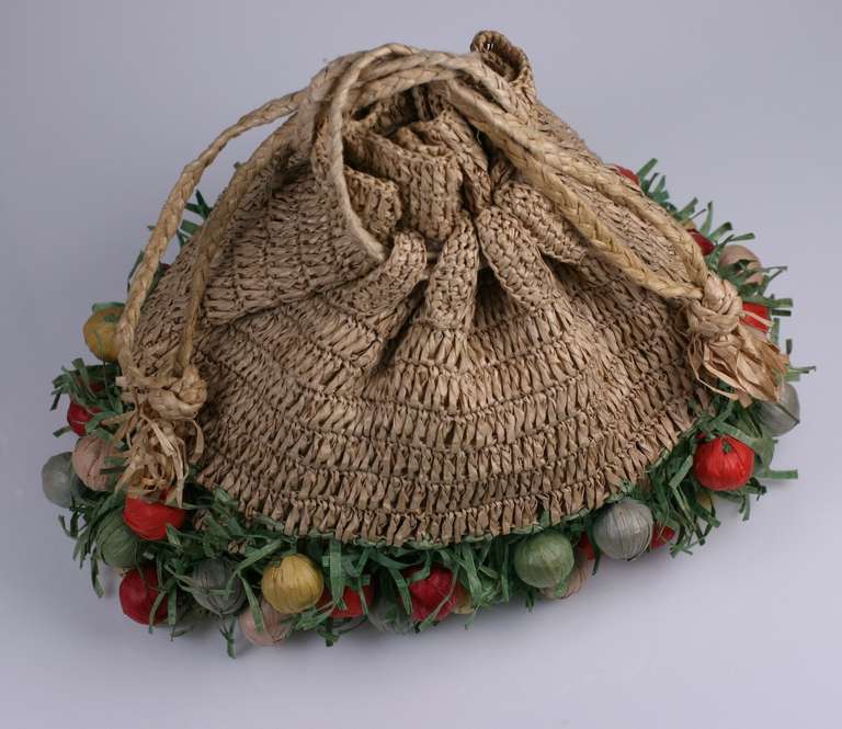 Amusing  Italian knitted natural straw resort bag  decorated with multicolored round raffia fruits in a base of raffia grasses. Drawstring opening, lined in rayon. Excellent condition. 
11