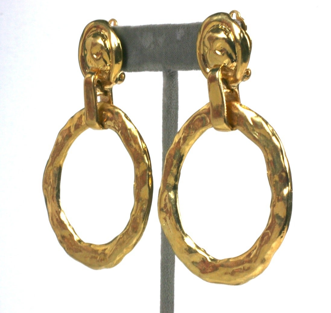 Hammered gold hoop earrings by Yves Saint Laurent inspired by Max Ernst. Large hoops fall from abstract 