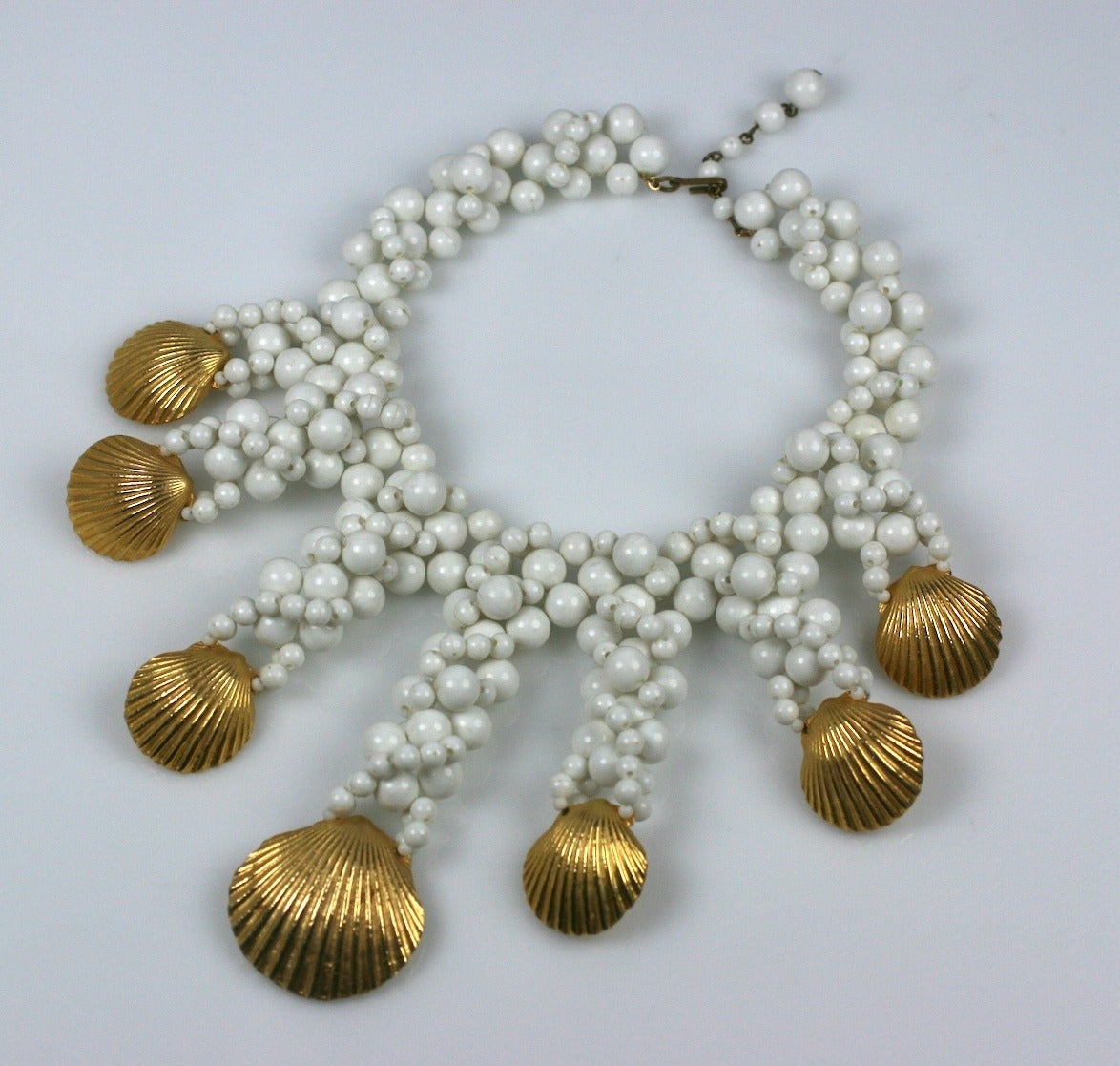 Gilt Shell and Woven Bead Bib from the 1960's. Extravagant scale with varied size white plastic beads forming tendrils down to gilt clams. 13-15