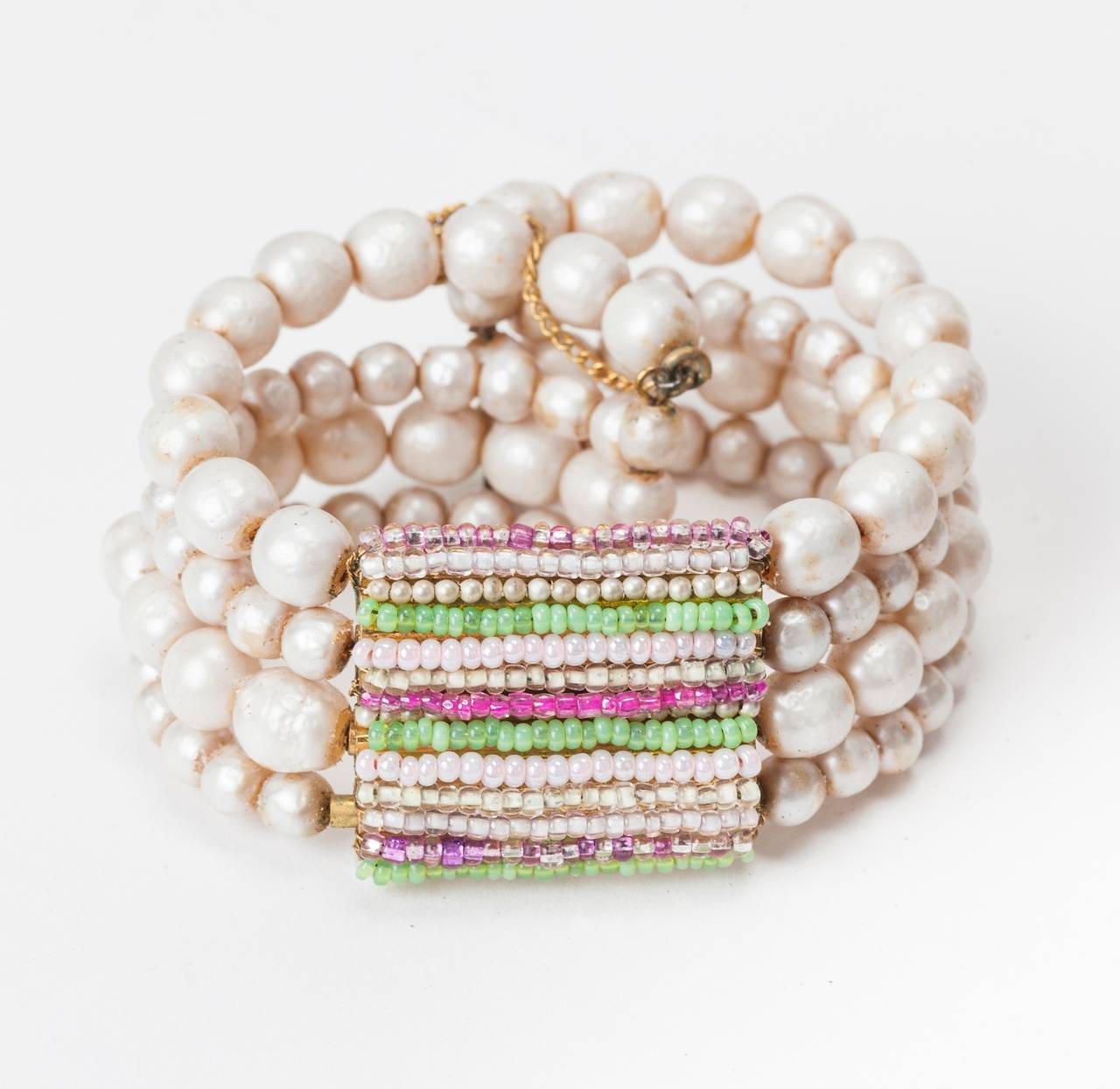 Miriam Haskell's signature Freshwater baroque, faux pearl flexible, wired bracelet. The center motif is composed of hand sewn sorbet colored seed beads and tiny pearls. 1950's USA. 
9