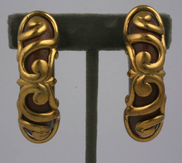 Dominique Aurientis attractive half hoop earclips of teak wood with overlaid gilt bronze scrollwork. France 1980's. Excellent condition. 
Height 2