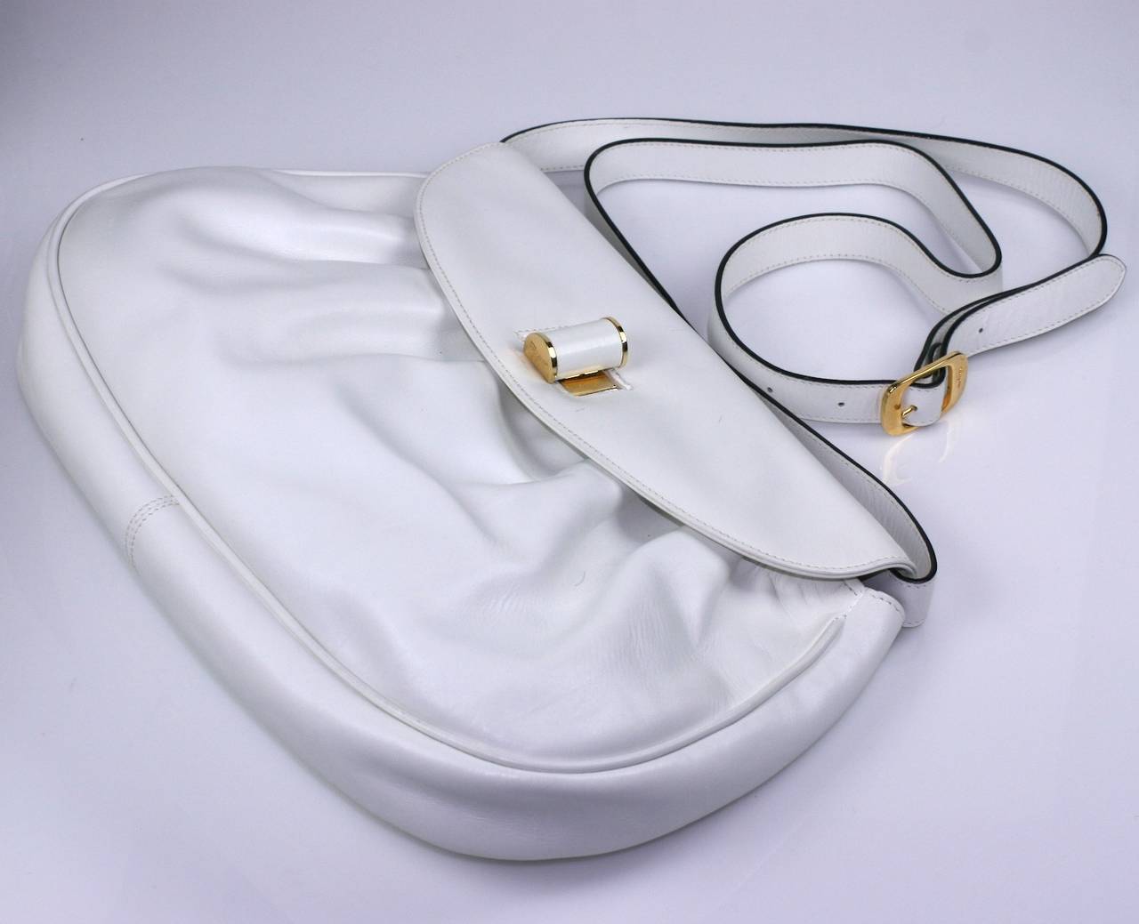 Ferragamo's slouchy white calf shoulder Bag with logo toggle and strap buckle.
Strap can be removed so can be used as clutch. Leather is gathered near flap for fullness.  
13