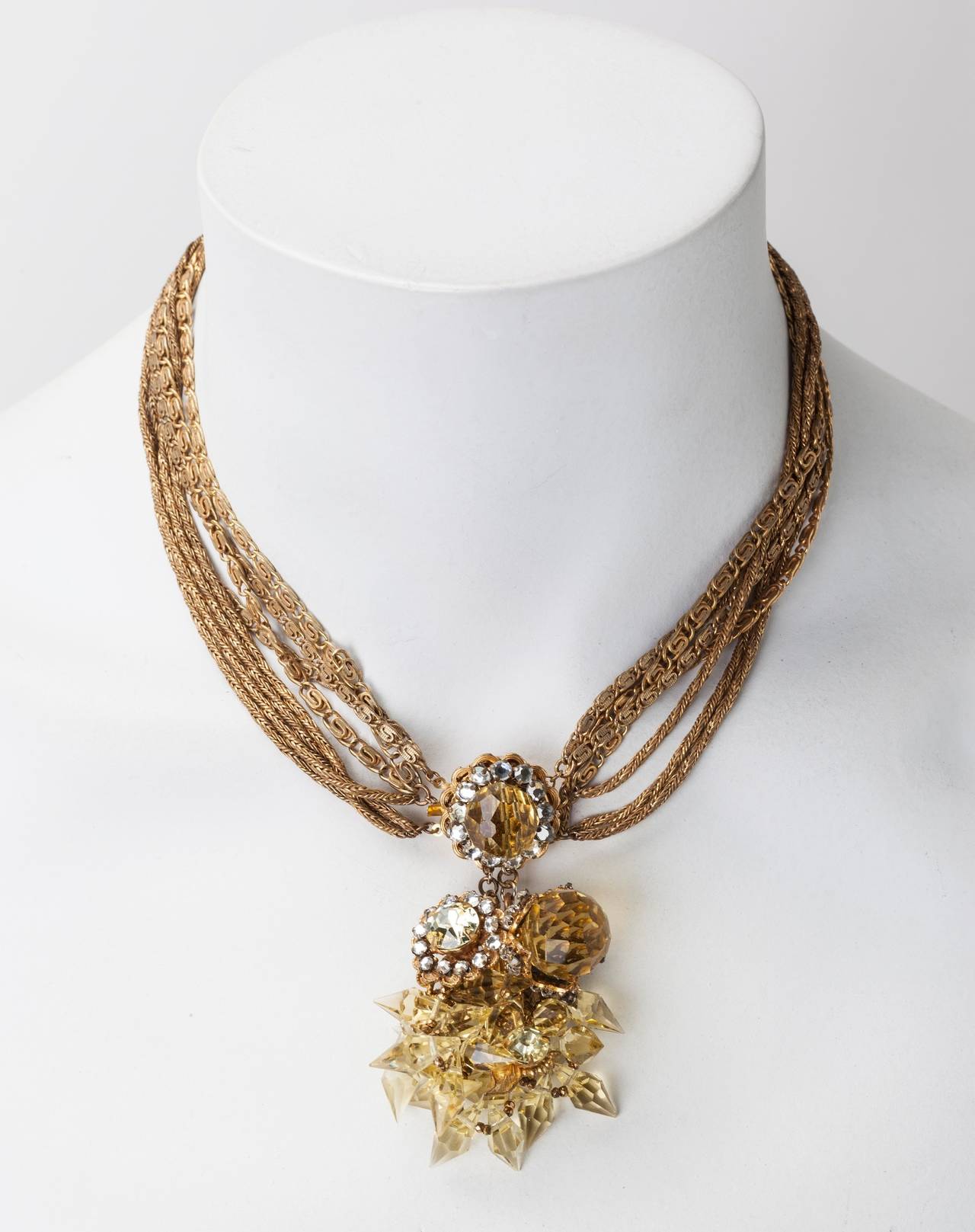 Miriam Haskell signature Russian Gilt, multi strand chain necklace with large central pendant clasp of faceted faux citrine round and pointed crystals. The clasp is further embellished with hand sewn crystal rose montes, and tiny gold cut steel