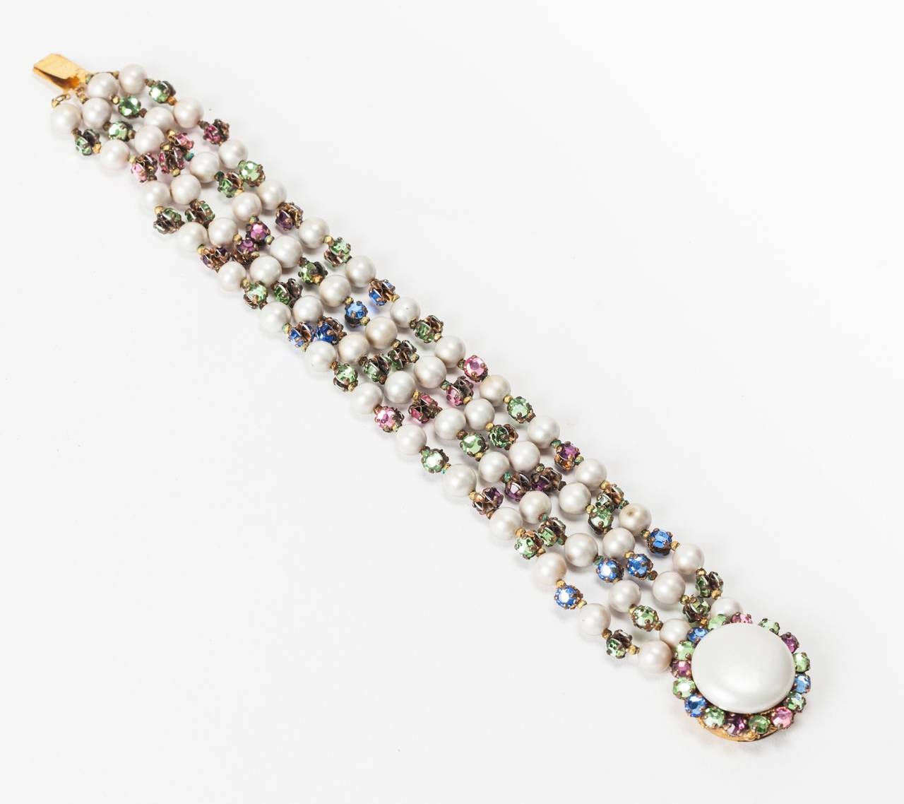 Lovely Miriam Haskell four strand bracelet of signature freshwater faux pearls and hand sewn multi pastel colored rose monte crystals spacers. Round button pearl clasp edged in pastel rose montes. 1940's USA. Excellent condition.

L7.75