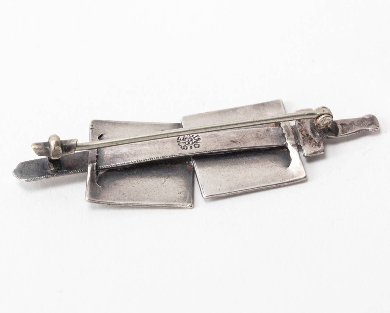 19th Century Sterling brooch in the Aesthetic style with a large sword piercing 2 ancient warrior 
