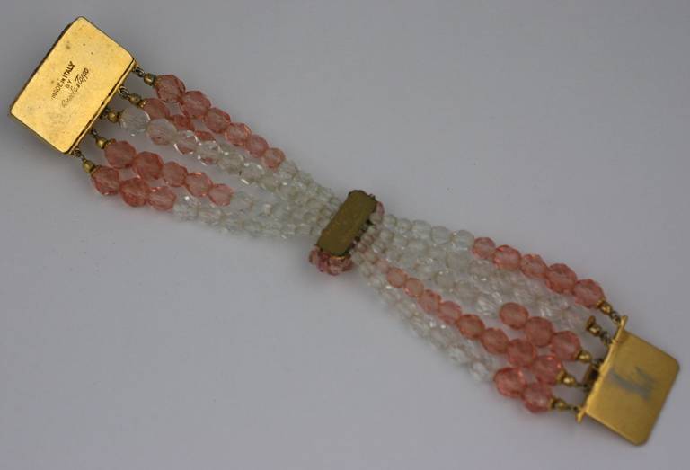 Bracelet à cinq brins Coppola e Toppo, de couleur pêche pâle à cristal, avec nœud papillon. De perles de cristal facettées et d'un fermoir multi-cristaux signature doré. Italie années 50.
Largeur du fermoir 1.50
Longueur 6.75