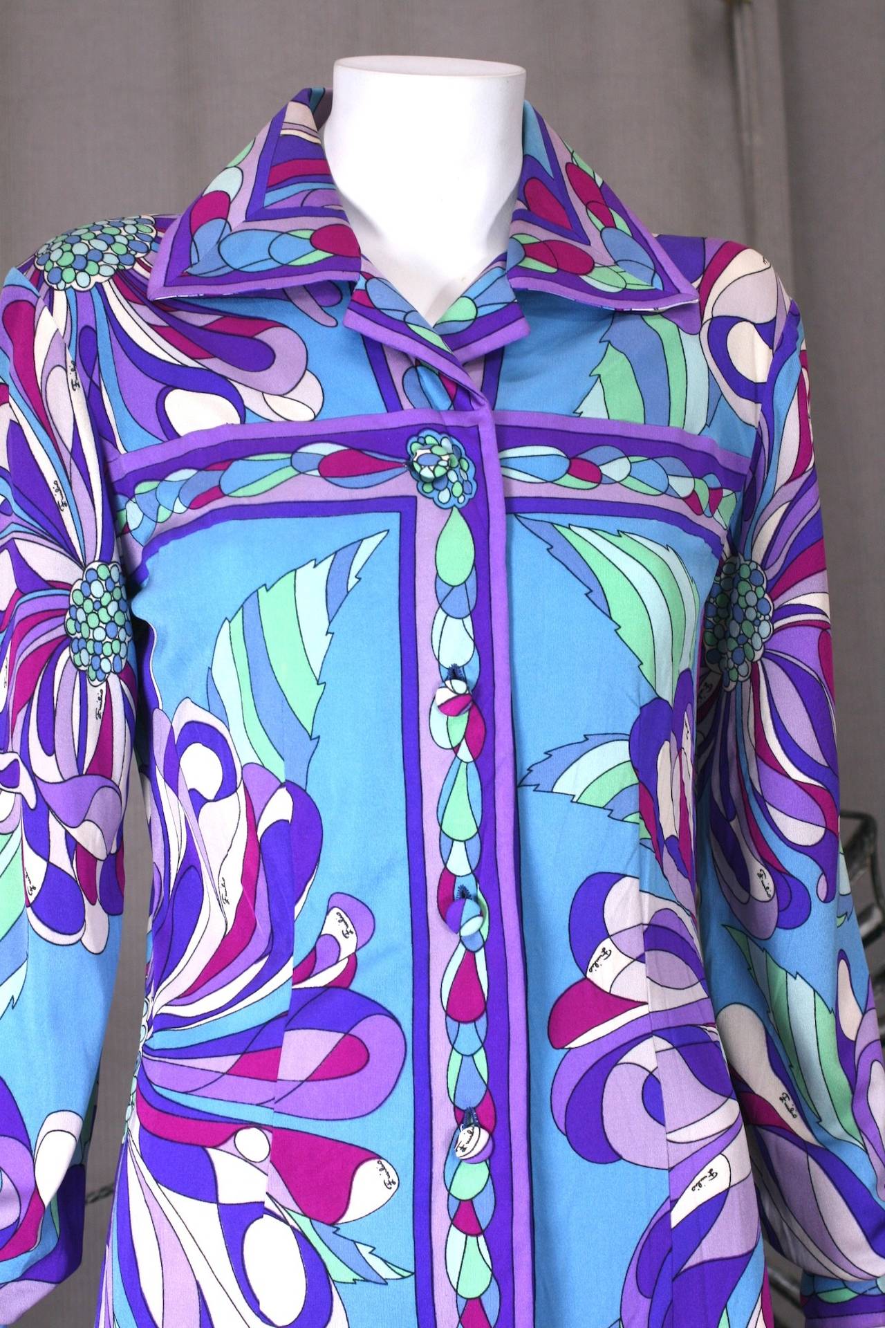 Emilio Pucci's elegant side slit shirtwaist in super graphic,vibrant silk jersey florals. Very demure from the front, but, with one elongated slit on left hip which opens and closes with covered buttons. Button front entry. 
Bust 34