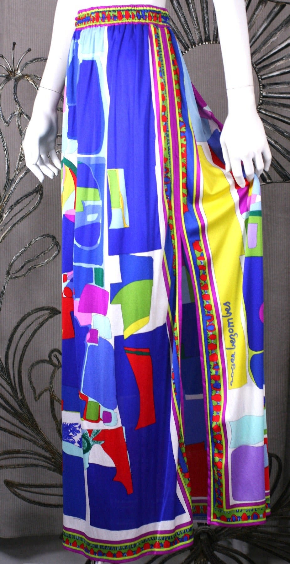 Synthetic knit maxi beach skirt by Leonard, Paris with slit which can be worn in different positions. Elastic waist entry. Colorful graphics by French artist Roger Bezombes (signature on slit). Predominantly on blue base. France 1980's. 
Excellent