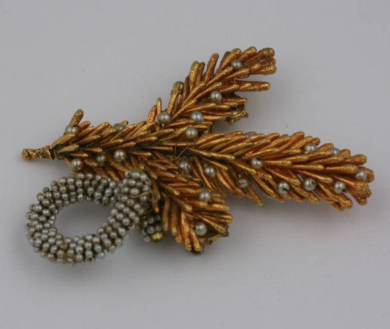 Miriam Haskell  Brooch of a natural pine frond  plated in 24 carat gold, the needles of the frond further enhanced with small round pearls,and a micro pearl pave ornament. 

3
