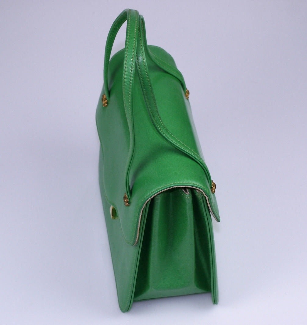 Charming Apple Green Leather Day Bag with multiple compartments from the 1960's. Double handled with pull tab closure. This bag adds a great shot of color to any occasion. Excellent condition, unused. 1960's USA.
7.5