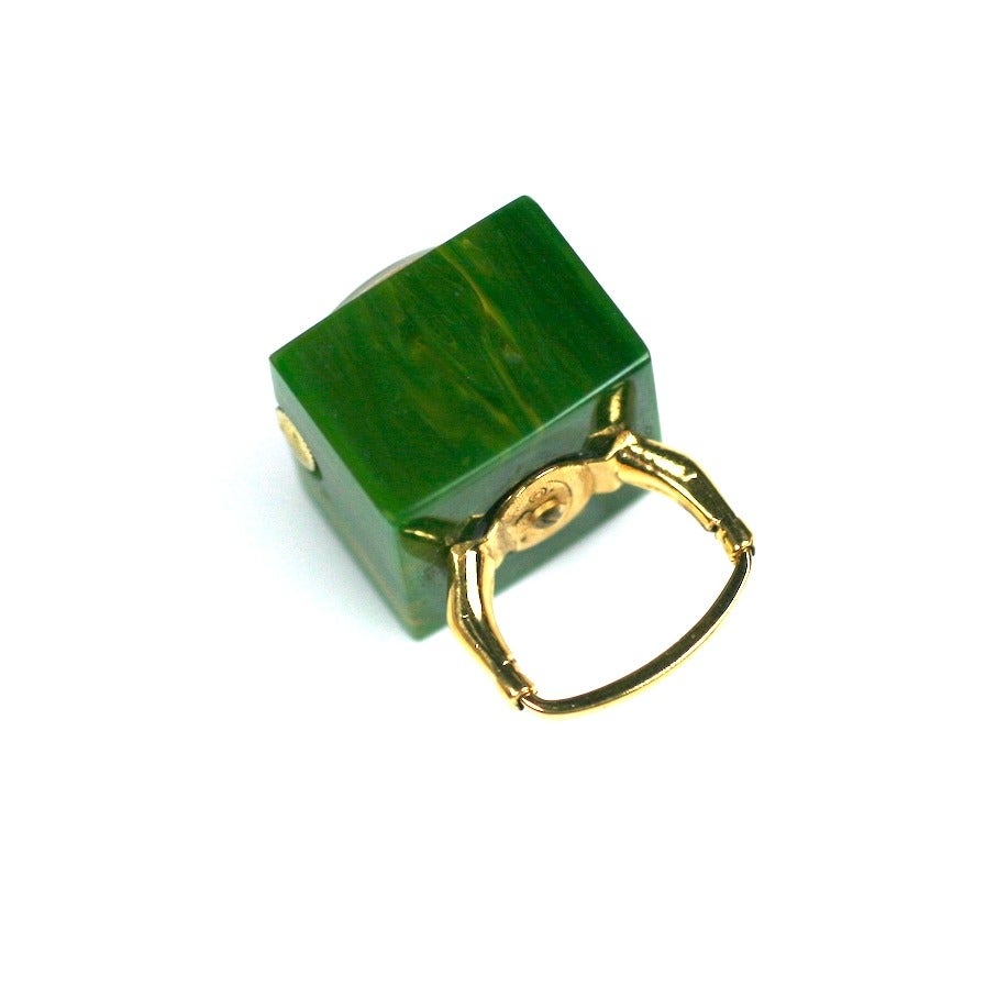 Unique Vendome Bakelite Watch Ring from the 1960's. End of day Bakelite in green with lighter striations is embedded with a working watch and set as a ring. Adjustable band fits all sizes. 17 Jewels, Swiss manufacture.
1960's USA. 1