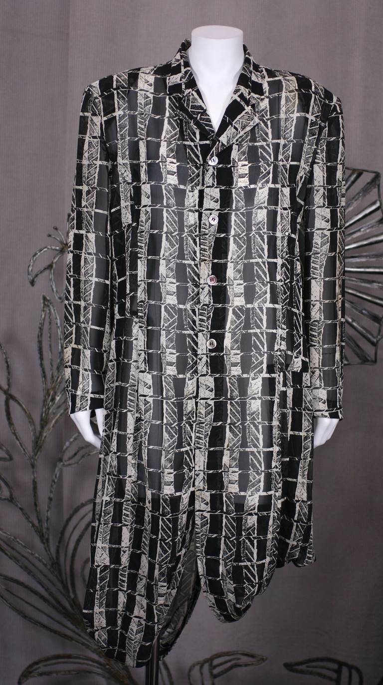 Early Comme des Garcons Sheer Coat Dress in graphic black-white print. Simply tailored and falling from strong shoulder pads. The top is cut like a mans overcoat but the hem is doubled onto itself assymetrically. The front and back panels are cut in