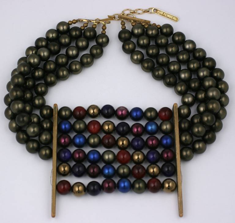 Jay Feinberg multi strand collar in bronze toned 12 mm faux pearls with centerpiece of multicolored pearls in wonderful jewel tones. The spacers are large gilt wood elongated triangles. Large and imposing collar with adjustable chain closure. 1980's