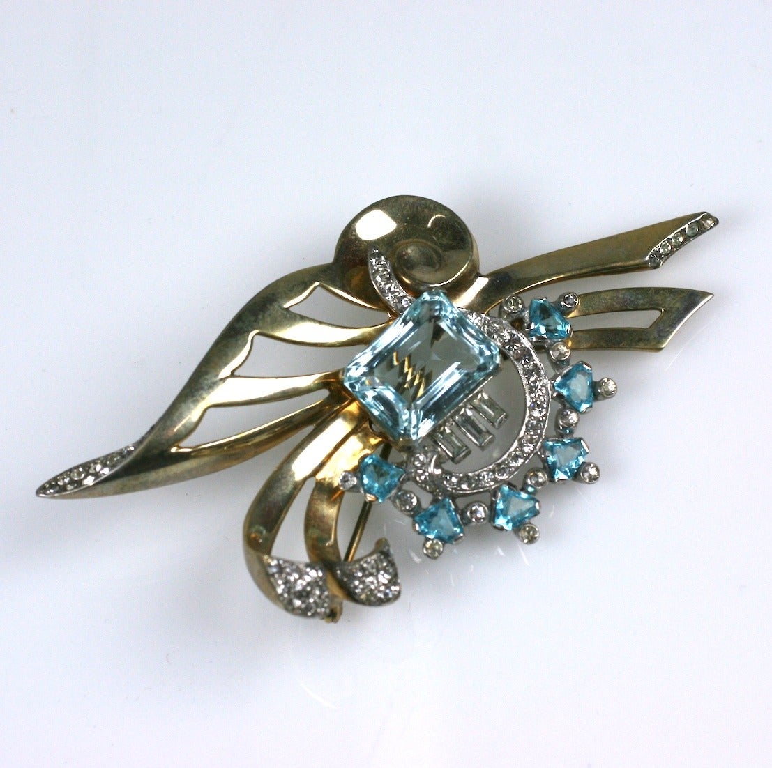 Mazer brothers, gold washed sterling silver Retro style brooch. An abstract butterfly in brooch form, set with crystal paste rounds and baquettes,and fancy cut faux aquamarines. 1940's USA. 
Excellent condition. L 3.25