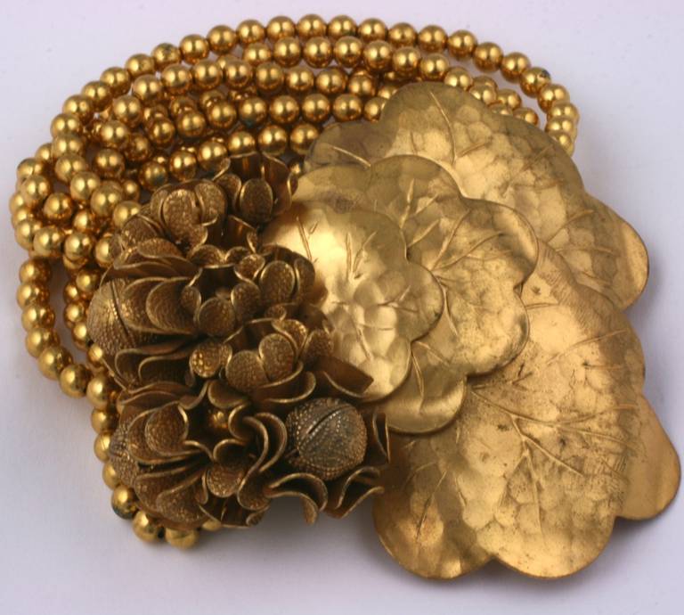 Early Miriam Haskell bracelet composed of many strands of gilt beads on elastic with a large cluster of signature wired flower heads and lily pads. Signature Russian gold finish used by Miriam Haskell. Motif 3 x 3