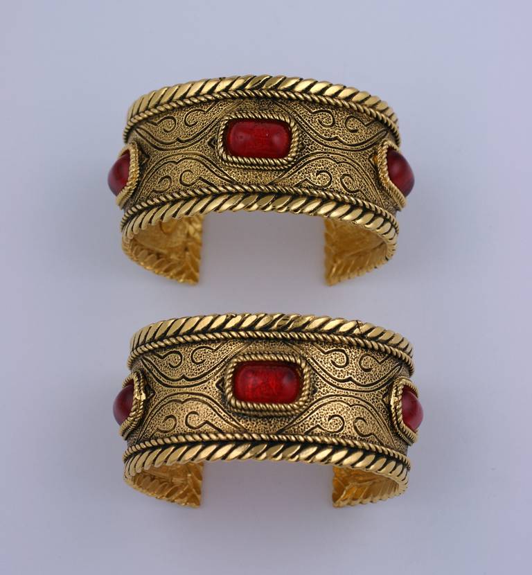Wonderful pair of Chanel Byzantine style cuffs with ruby pate de verre stones by Gripoix. Cuffs are set in  Antiqued gold finish with twisted wire bezels around each sugar loaf stone. Each setting is set into the cuff (as opposed to stones just