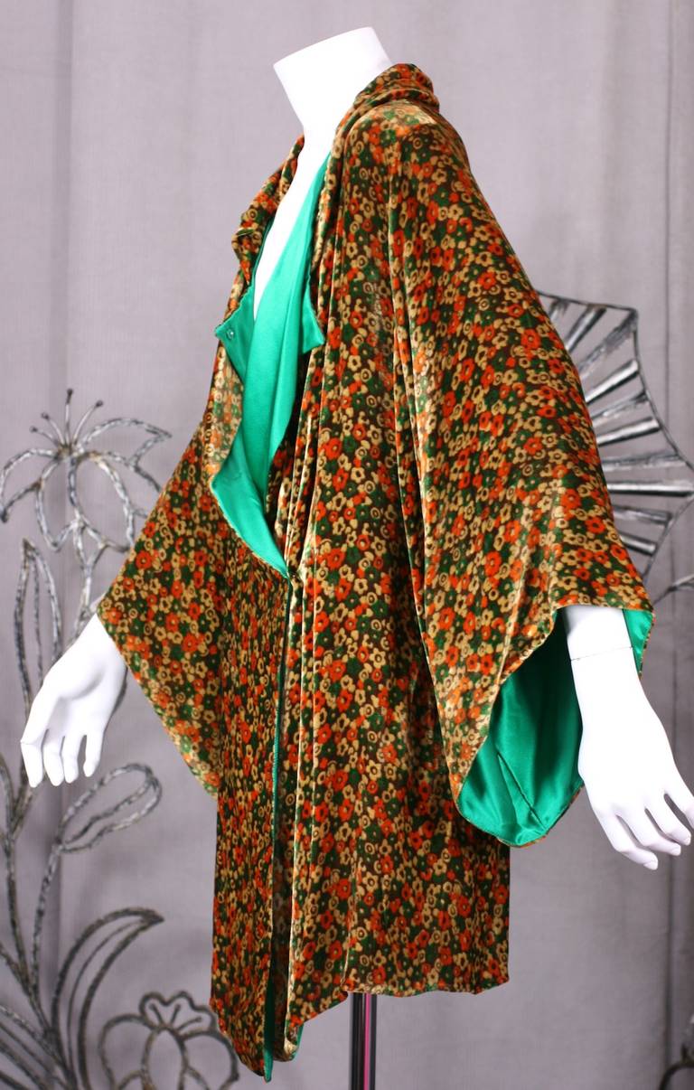 Luxurious floral print silk velvet kimono sleeved jacket in a palette of oranges, browns and greens. This has been relined in emerald silk satin and has 2 covered snaps at the neck for closure. When closed there is a small rolled collar.
Please