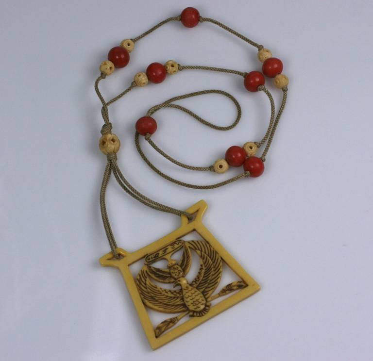 Art Deco Egyptian Revival long pendant necklace inspired by the discovery of Tut's Tomb in 1922. The pendant shows the sacred vulture goddess Nekhbet.
 A cartouche at top has hieroglyphs of birds and a serpent. The same cartouche is also on the