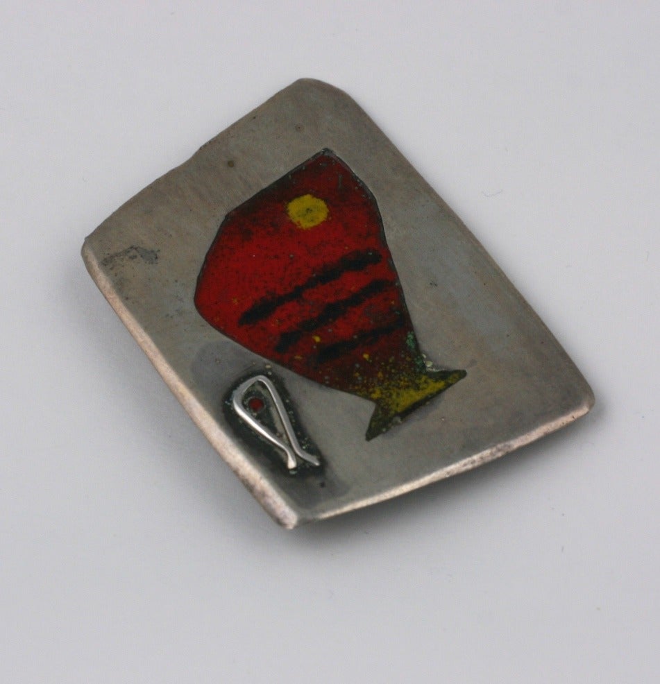 Betty Cooke Minnow brooch of sterling silver with red, yellow and black hard enamel accents. There is a back plate in copper which is signed.
1 3/8