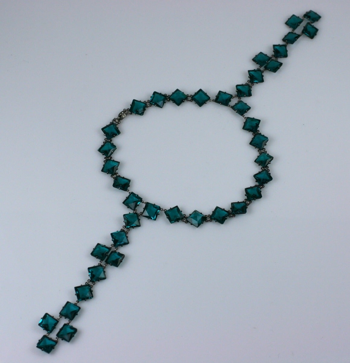 Extremely unusual and dramatic paste Art Deco double drop pendant necklace from the 1920's. A teal-green paste is used for the square shaped links and is mounted in different directions on the necklace. The open, dipping necklines of the period