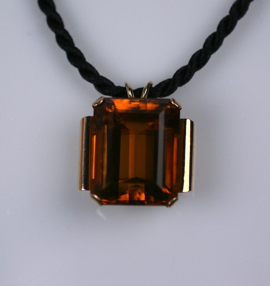 Ciondolo retrò incastonato in oro pesante 14k con citrino massiccio taglio smeraldo di circa 44 carati in una profonda tonalità cognac. Le spalle rivelano i bordi arrotolati tipici dei gioielli del periodo Retro.
La pietra misura 25 mm x 20 mm x 15