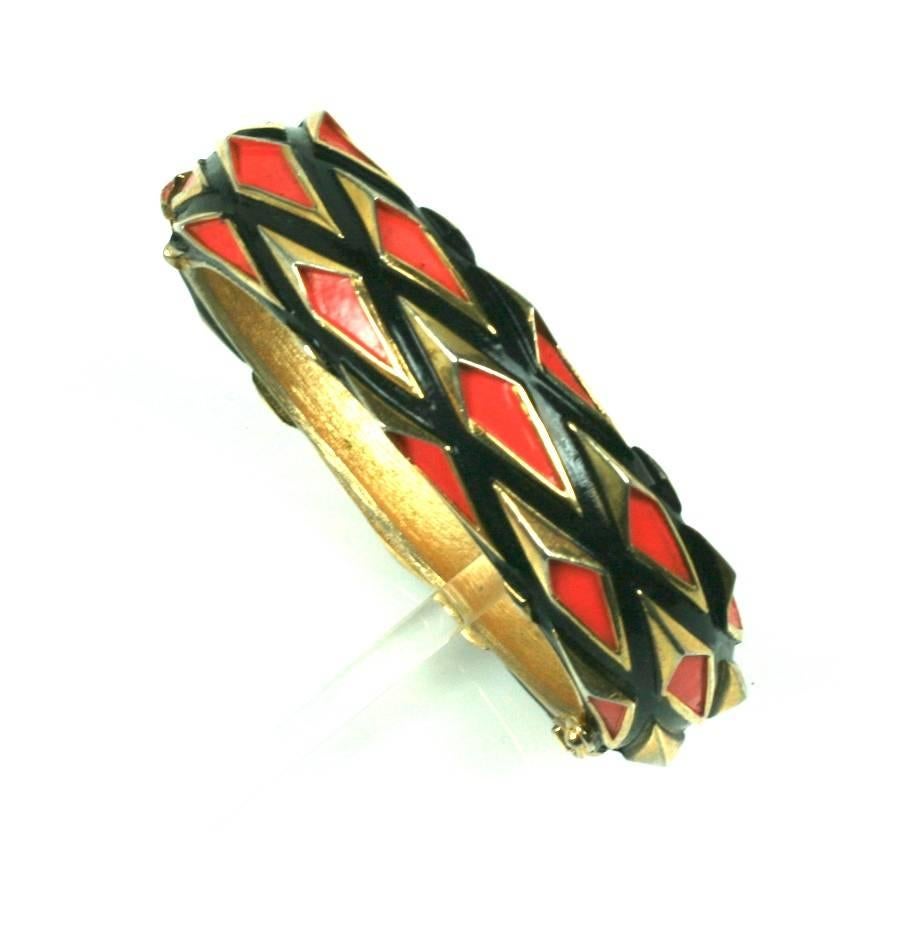 Modernist Trifari Bangle in gilt metal with orange and black enamel highlights.
The spikey design has almost a 3D printed effect, but, this was made in the 1960's. Hinge closure. 
.75