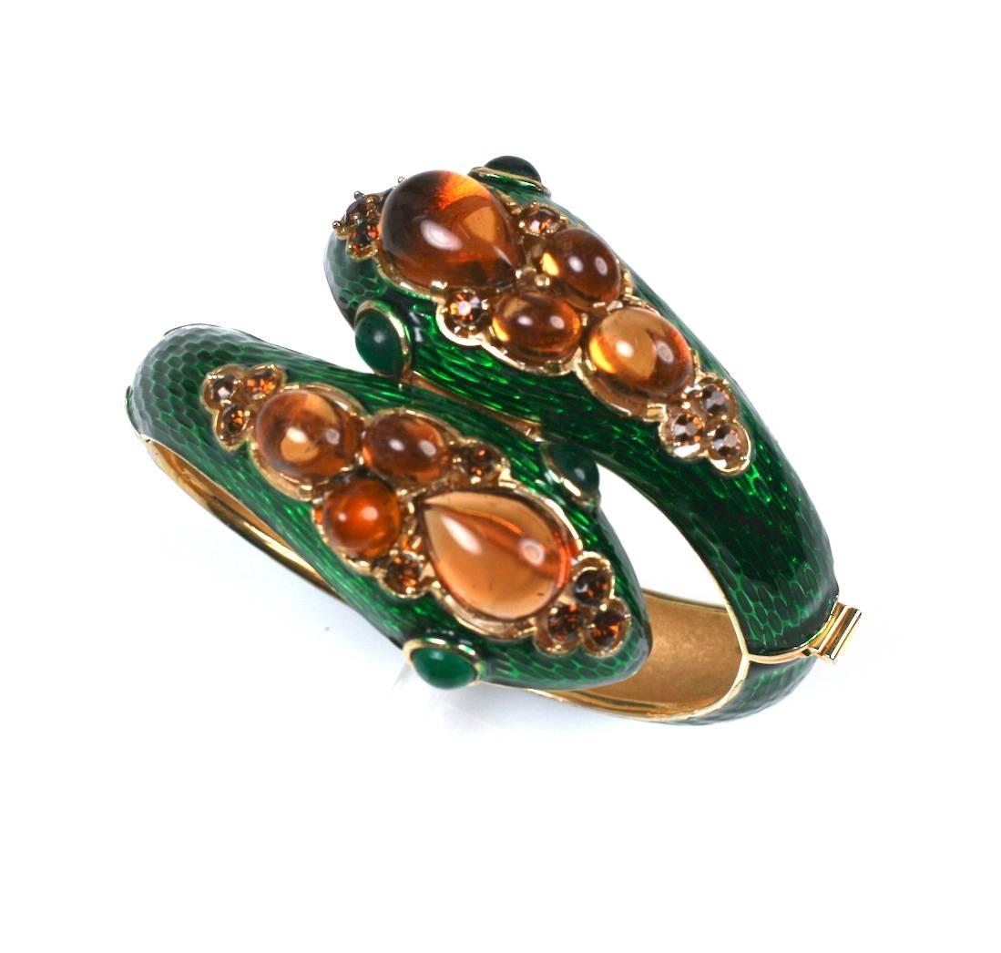 Wonderful Trifari Jeweled Snake Bangle in the style of David Webb. Deep green enamel is used to counterpoint the faux citrines in the heads of the snake. Large faux emerald cabochon eyes. Striking and elegant jewel. 
Excellent condition. 1960's